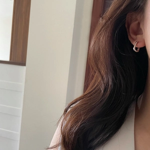 Boucles d'oreilles ovales en U argentées sur mannequin pour un style moderne