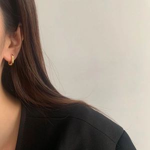 Créoles ovales en forme de U dorées minimalistes portées à l'oreille au fini métal poli