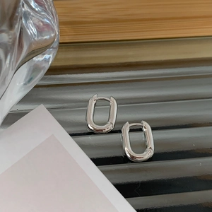 Vue rapprochée de boucles d'oreilles ovales en U argentées au fini poli brillant
