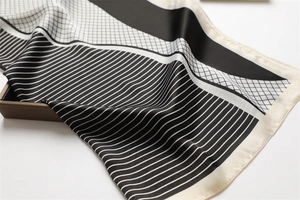 Detailed close-up of geometric pattern and fine stitching on high-quality satin scarf