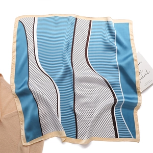 Macro detail of geometric plaid square silk scarf with smooth texture and hemmed edges
