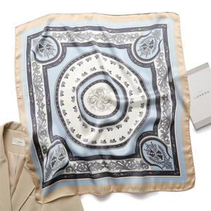 Dettaglio di un foulard in seta di lusso con stampa di carrozze su un blazer