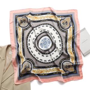 Dettaglio di un foulard effetto seta con motivi vintage di carri e volute barocche dorate