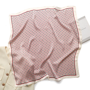 Flat lay of silk scarf with red horse print next to tweed jacket and fashion magazine