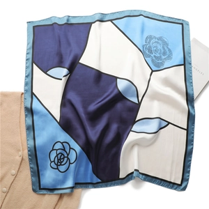 Detail of camellia floral print on a 70cm satin silk scarf with geometric color block design