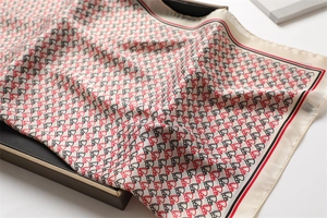 Macro shot of silk scarf with equestrian horse head patterns on a black gift box