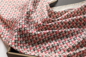 Detailed close-up of luxurious horse head pattern print on silky white square scarf fabric