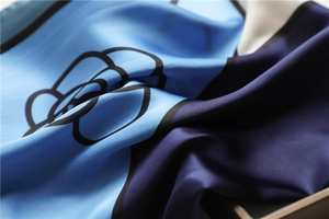 Detail of silk scarf with blue color block and elegant camellia pattern texture