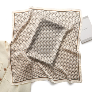 Detail of silk square scarf with horse head monogram and elegant London book styling