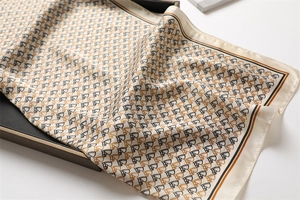 Detail of silk scarf with equestrian horse head print folded on a black display box