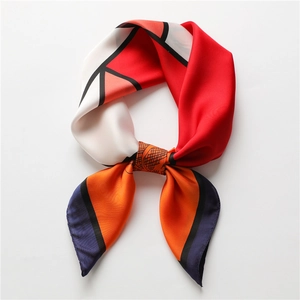 Detailed close-up showing silky texture and geometric color-block pattern of the scarf