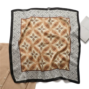 Détail d'un élégant foulard en soie à motif floral à quatre feuilles et bordure noire