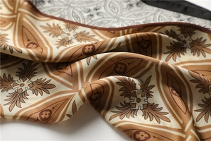 Détail de foulard en soie vintage caramel avec motifs géométriques et éclat satin