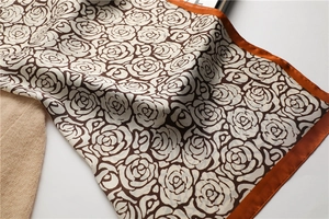 Close-up of silk scarf with brown rose floral patterns and caramel borders on soft wool