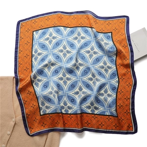Détail du motif rétro à quatre feuilles sur un foulard carré soyeux et brillant