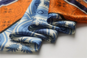 Gros plan du foulard en soie orange et bleu avec motif floral vintage et satiné