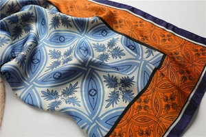 Détail d'un foulard en soie vintage avec motifs bleu et orange et texture satinée