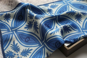 Texture détaillée du foulard en soie vintage bleu et blanc avec motifs géométriques élégants