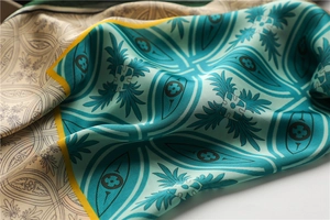 Détail d'un foulard en soie vintage montrant le motif floral géométrique bleu et beige