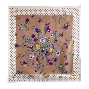 Detailed pattern of floral silk scarf with brown polka dot border and vibrant colors