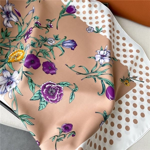 Close-up of silk scarf showing floral tulip patterns and brown polka dot edges