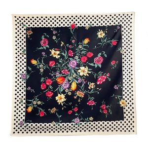 Macro detail of floral patterns and classic black polka dots on the square silk scarf
