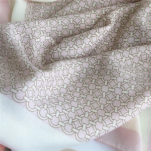 Detailed close-up of retro chain pattern on soft pink and beige silk-texture scarf