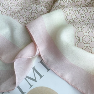 Close-up of pink and cream chain print scarf showing silky texture and machine-rolled hem