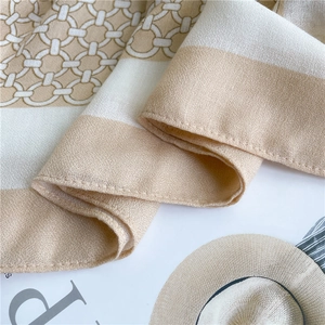 Detailed macro view of geometric chain pattern and fine stitching on beige linen shawl
