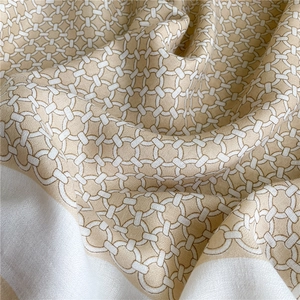 Detail of interlocking chain pattern on soft beige and white cotton linen scarf fabric