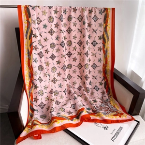 Detail of pink cotton linen scarf with floral geometric patterns and bright orange borders