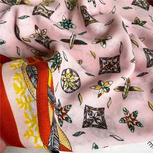Detail of pink cotton linen scarf featuring ethnic feather prints and silky texture