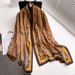 Luxurious cotton linen scarf with vintage feather print draped over a black leather handbag