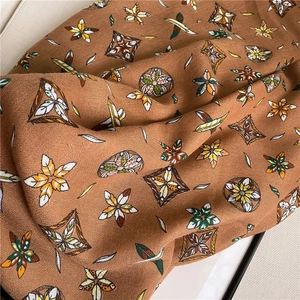 Macro detail of bohemian geometric pattern on soft cotton-linen scarf with brown earth tones