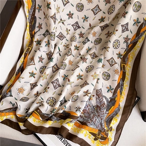 Detail of bohemian scarf with feather and star patterns on a soft white armchair