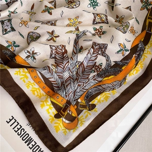 Detailed close-up of premium cotton-linen scarf with elegant feather and strap patterns