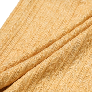 Vue macro d'un tricot jaune gingembre avec motif côtelé et détails géométriques texturés
