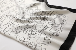 Detail shot of silk-like satin scarf with classic perfume print and black border