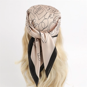 Elegant champagne silk square scarf with black abstract lines worn as a stylish headscarf