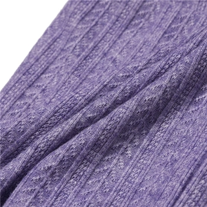 Vue macro du tricot violet avec motifs de torsades classiques et texture de côtes