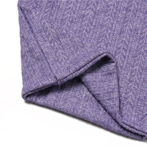 Vue macro d'une écharpe en tricot violet montrant la texture des mailles et le tissu côtelé