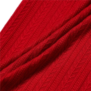 Gros plan d'une écharpe en tricot rouge avec des côtes et motif en épi de blé