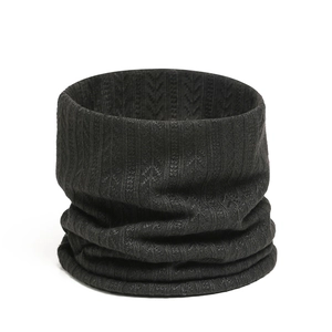 Détail du cache-col en tricot noir montrant le motif de blé et la texture côtelée