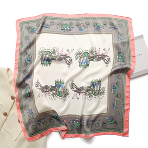 Close-up of silk square scarf featuring classic horse carriage patterns and orange border