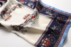 Macro shot of silk scarf showing vintage carriage print and smooth satin texture details