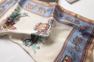 Detail of luxury silk scarf showing vintage horse carriage pattern on ivory satin fabric