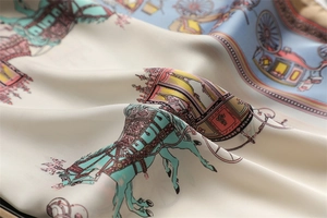 Macro detail of silk scarf featuring classic horse carriage patterns with smooth texture