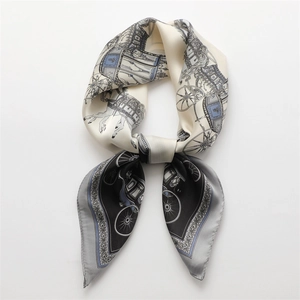 Detail of luxury silk scarf with vintage carriage pattern and floral accents in blue and black