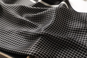 Detailed close-up showing the smooth satin texture and black and white checkered pattern
