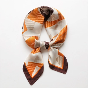 Detail of a geometric printed silk scarf tied in a bow with orange and brown patterns